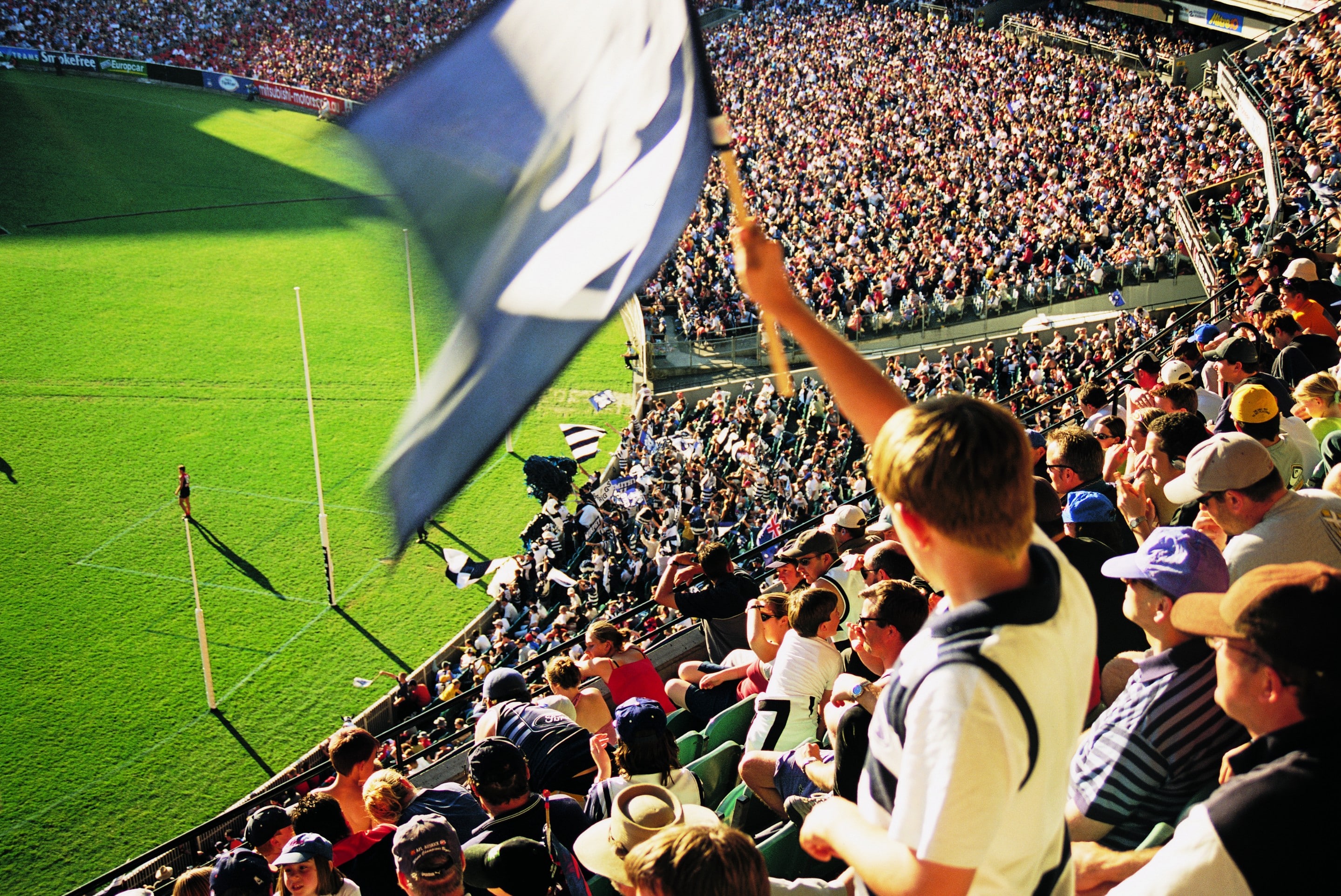 Fan waves flag at the AFL grand final in Melbourne © Tourism Victoria