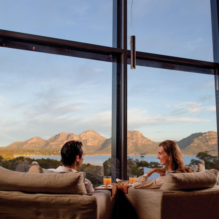 Couple relaxing in lounge with view over Freycinet National Park © Saffire Freycinet