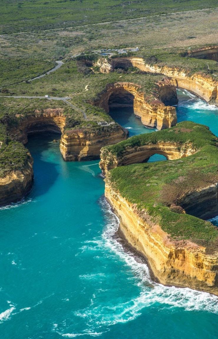 Aerial view over cars driving on a road beside a coastline with sandstone cliffs, Great Ocean Road, Victoria © Greg Snell Photography