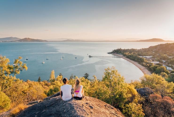 Two girls sat on Hawkins Point looking out to sea © Tourism and Events Queensland