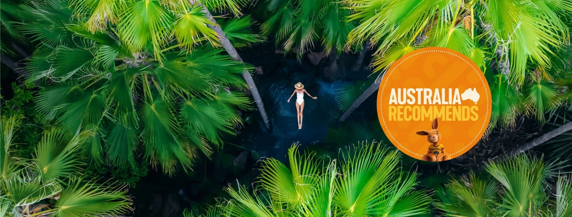Aerial of woman floating surrounded by palm trees in Zebedee Springs, Kimberley, Western Australia © Tourism Australia