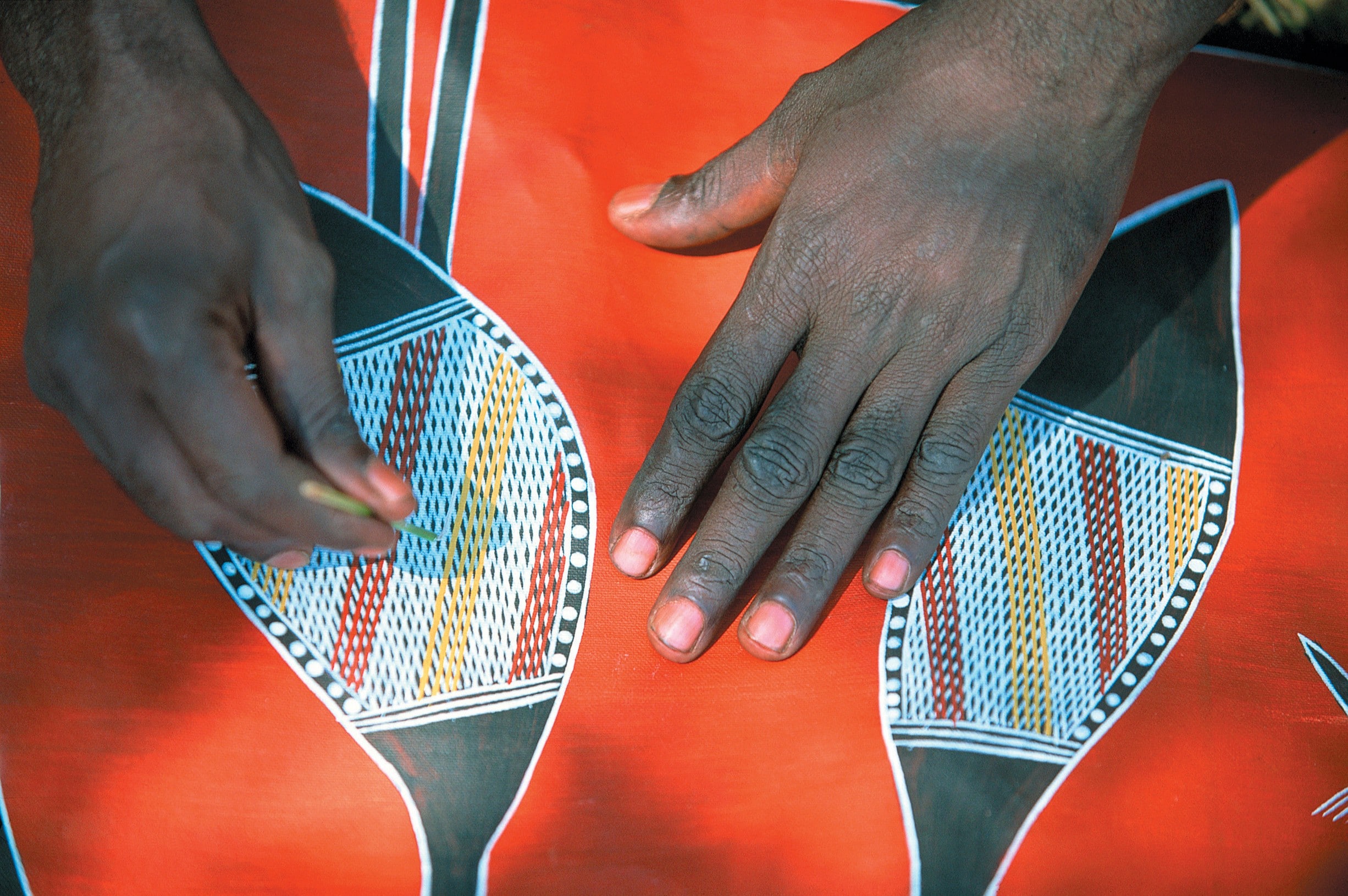 Aboriginal artist working on a dot painting © Tourism NT
