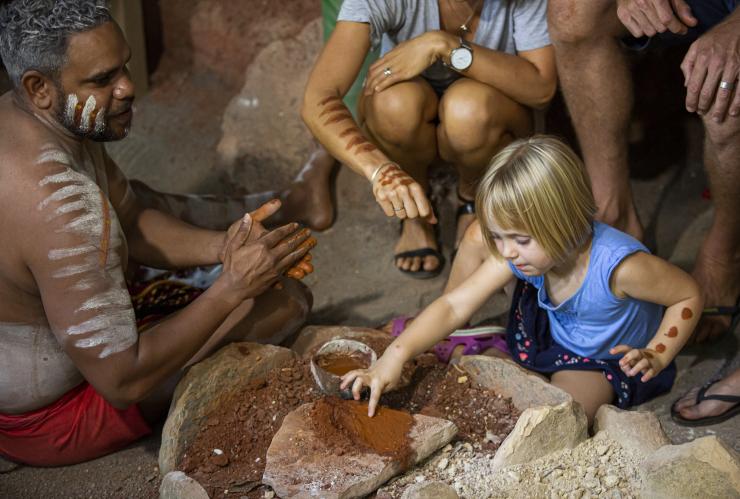 A family painting their arms using ochre alongside a local Aboriginal guide wearing traditional body paint at Rainforestation Nature Park during the Pamagirri Aboriginal Experience, Kuranda, Queensland © Artra Sartracom