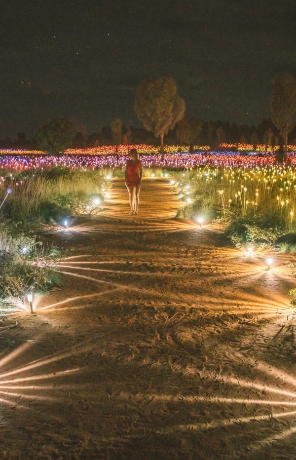 A visitor walking through the Field of Light art installation © Tourism NT/Mitchell Cox