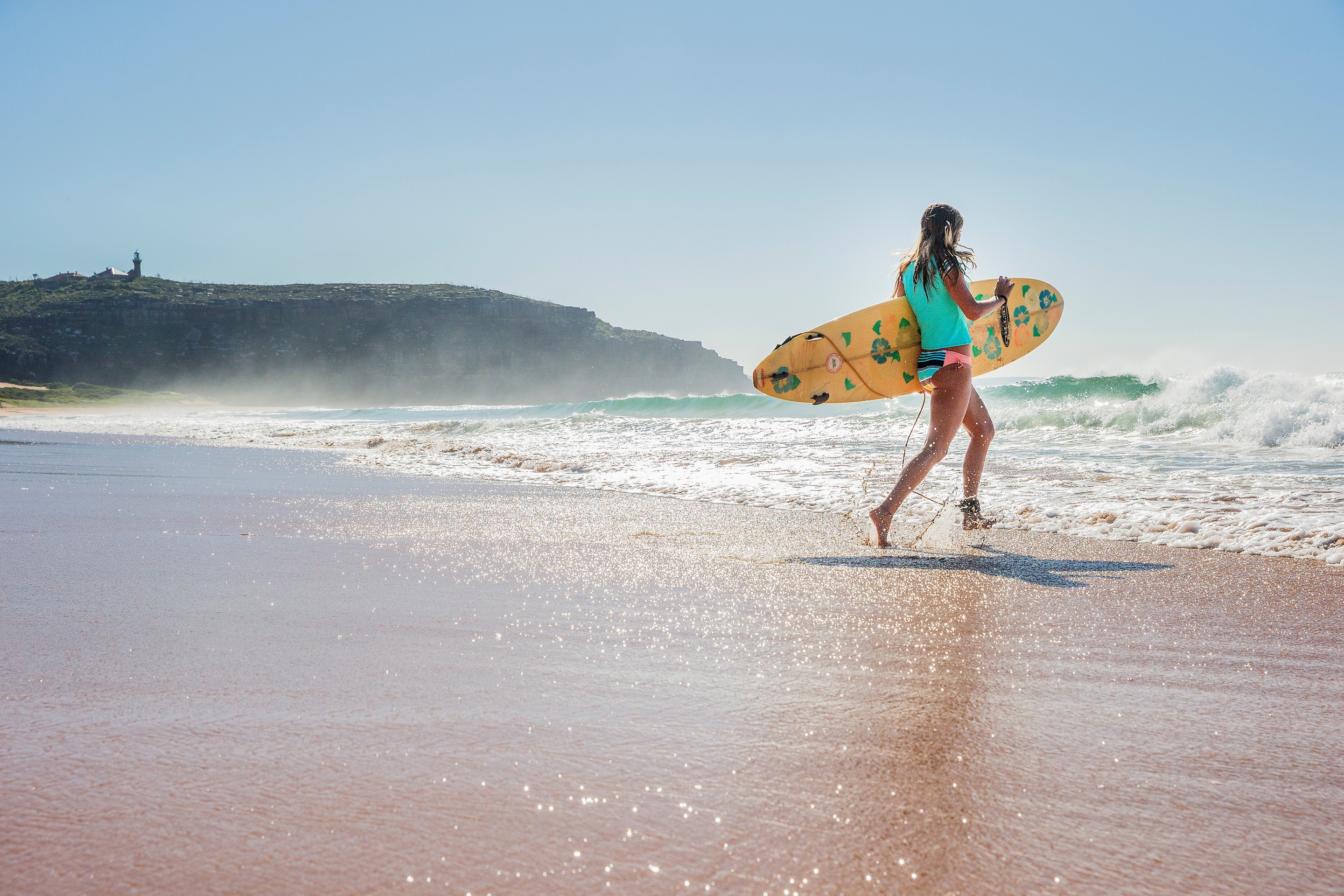 Surfer runs into the ocean at Palm Beach in New South Wales © Destination NSW