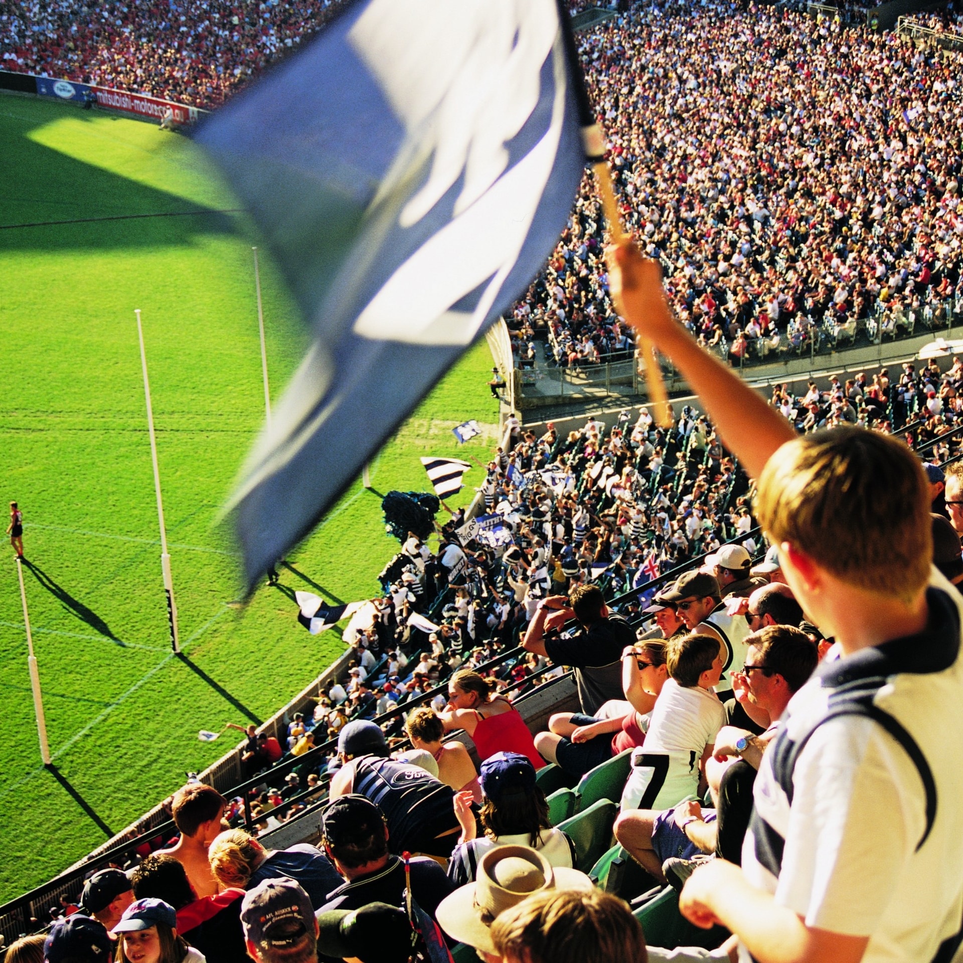 Un fan brandit le drapeau lors de la grande finale de l'AFL à Melbourne © Tourism Victoria