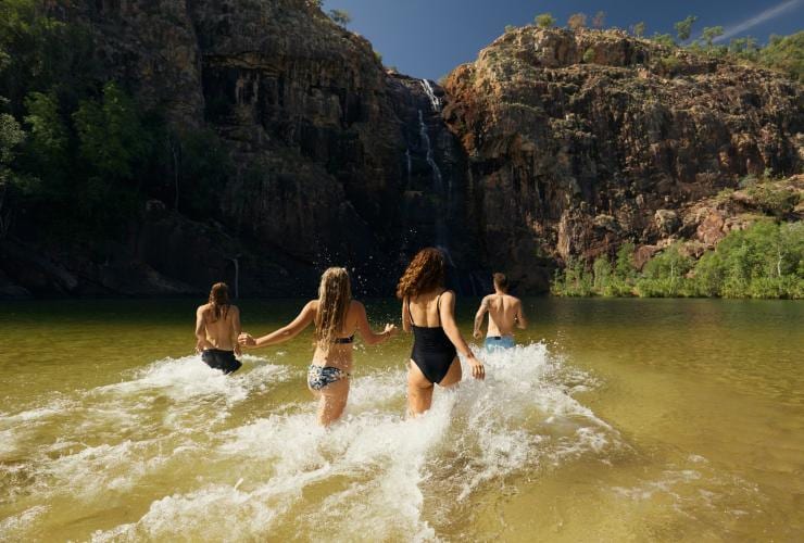 Une famille courant vers les chutes de Gunlom Falls dans le Kakadu National Park dans le Territoire du Nord © Tourism NT/Matt Cherubino