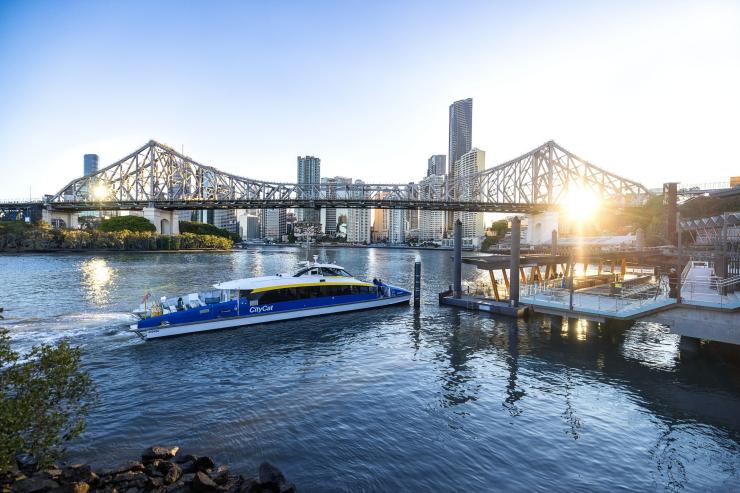 Feri di Sungai Brisbane dekat Fortitude Valley dengan Jembatan Story dan gedung pencakar langit kota di latar belakang di bawah sinar matahari sore yang hangat, Queensland © Tourism Australia