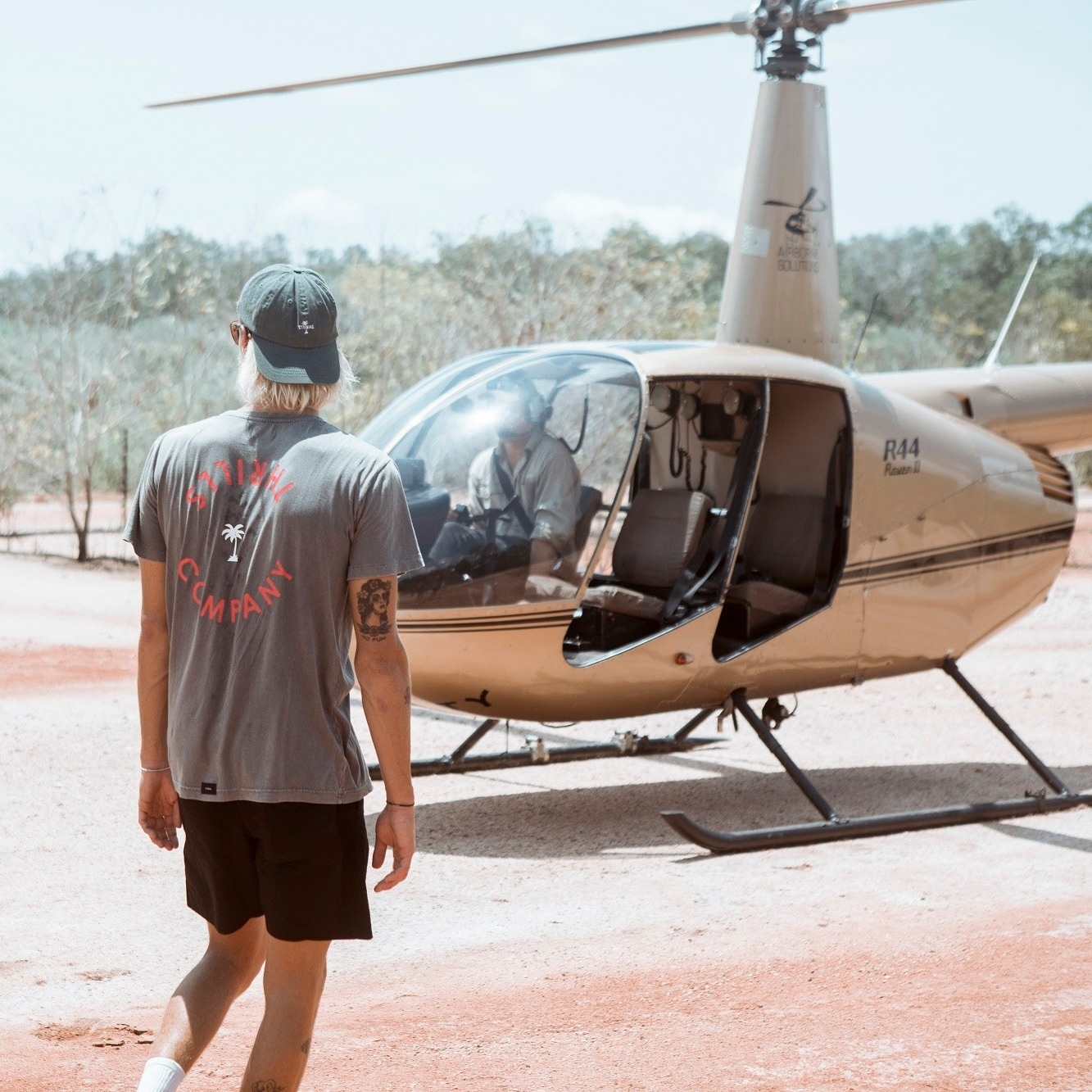 Pasangan naik helikopter untuk mendatangi pub dekat Darwin © TourismNT