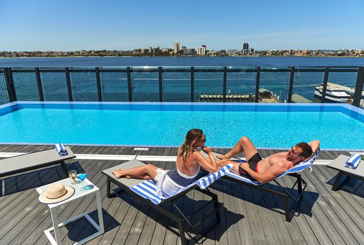 Pasangan berjemur di tepi kolam renang di puncak gedung DoubleTree by Hilton Waterfront, Perth, Western Australia © DoubleTree by Hilton Perth Waterfront