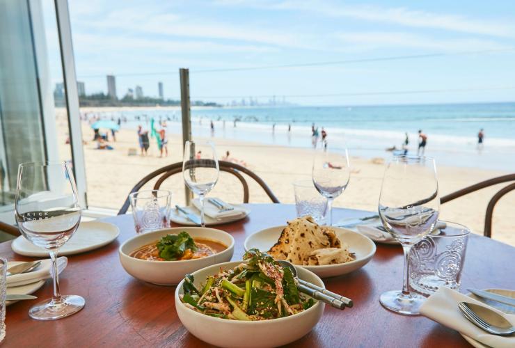 Set meja dengan makanan dan minuman di Rick Shores Restaurant di Gold Coast © Tourism and Events Queensland