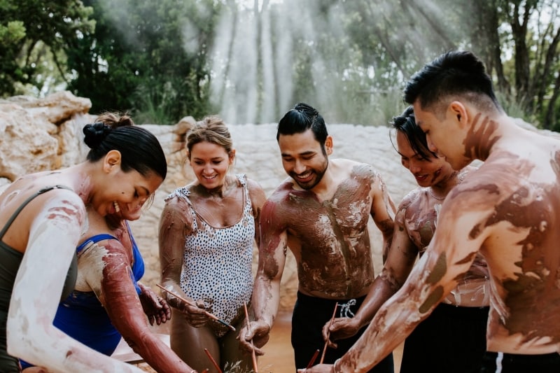 Sekelompok teman bergabung dalam ritual tanah liat di Peninsula Hot Springs © Peninsula Hot Springs 