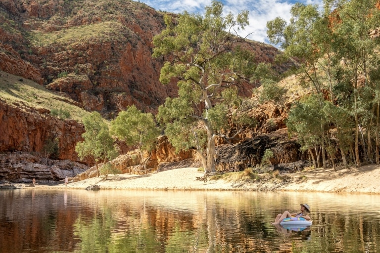  Seorang perempuan sedang berjalan di atas Kings Canyon saat matahari terbit © Tourism NT/Mitchell Cox 2017