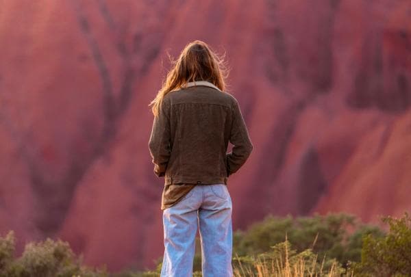 Seorang wanita melihat ke Uluru, Northern Territory © Tourism NT/Plenty of Dust