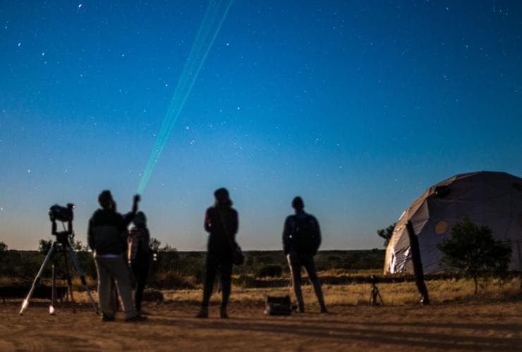 Siluet orang mengamati bintang di Earth Sanctuary World Nature Centre © Tourism NT/Shaana McNaught