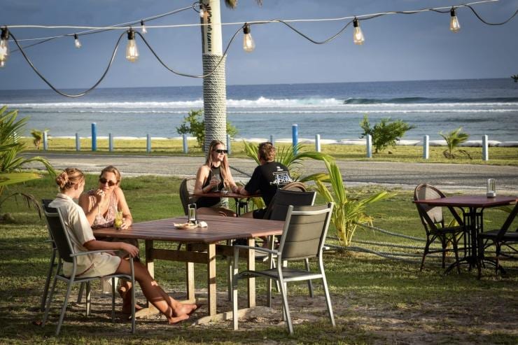 Beberapa pengunjung sedang duduk di meja piknik di bawah lampu gantung di Surfer Girl Brewery, Cocos (Keeling) Islands © Surfer Girl Brewery Beberapa pengunjung sedang duduk di meja piknik di bawah lampu gantung di Surfer Girl Brewery, Cocos (Keeling) Islands © Surfer Girl Brewery