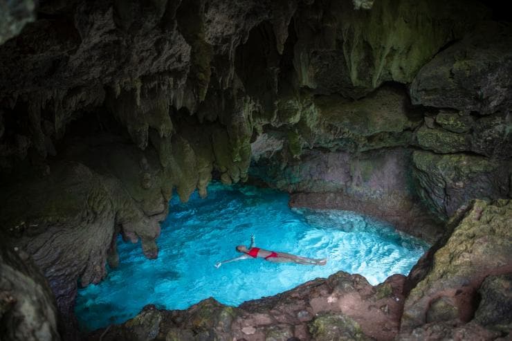 Seorang wanita sedang mengapung di perairan biru jernih di dalam gua di The Grotto, Christmas Island © Base Imagery Seorang wanita sedang mengapung di perairan biru jernih di dalam gua di The Grotto, Christmas Island © Base Imagery