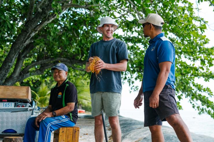 Seorang pengunjung yang sedang memegang kelapa tersenyum saat mengobrol dengan pemandunya pada Ossie’s Cultural Tour, Home Island, Cocos (Keeling) Islands © Cocos Keeling Islands Tourism Association Seorang pengunjung yang sedang memegang kelapa tersenyum saat mengobrol dengan pemandunya pada Ossie’s Cultural Tour, Home Island, Cocos (Keeling) Islands © Cocos Keeling Islands Tourism Association