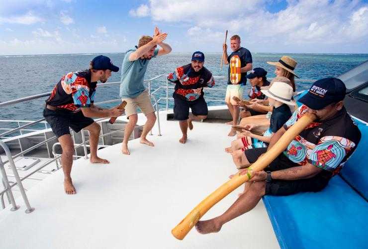 I visitatori partecipano a una cerimonia di benvenuto durante un tour di Dreamtime Dive and Snorkel © Tourism and Events Queensland