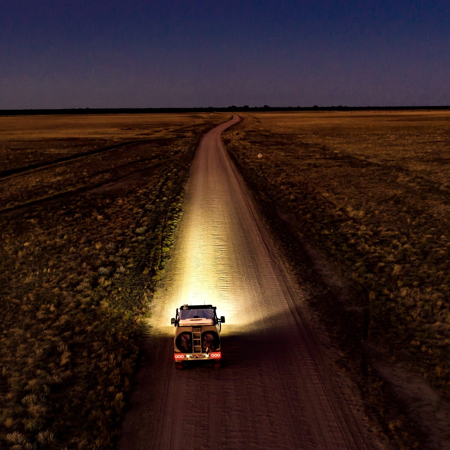 夜間にアウトバック・ウェイ沿いを走行する車 © Tourism and Events Queensland