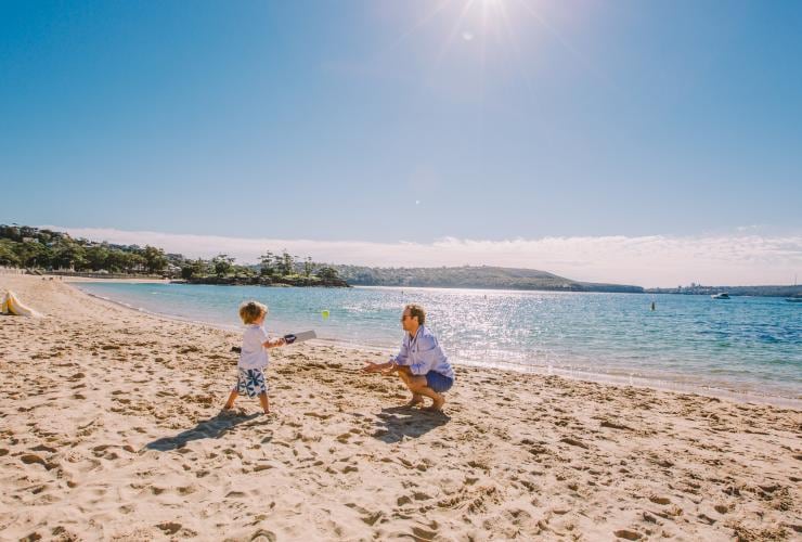 シドニーのバルモラル・ビーチで遊ぶ父と息子 © Tourism Australia