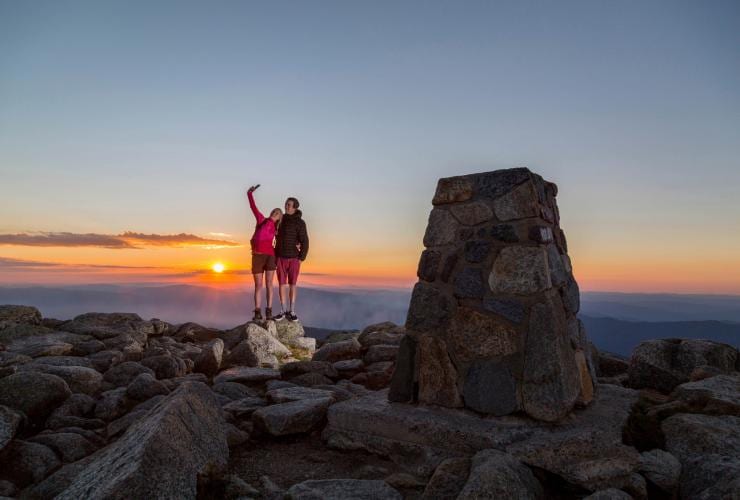 ニューサウスウェールズ州、コジオスコ国立公園にあるコジオスコ山の頂上で自撮りをするカップル © Tourism Snowy Mountains