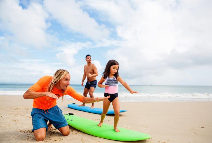 バイロン・ベイ、クラークス・ビーチでサーフィンのレッスンを受ける家族 © Destination NSW