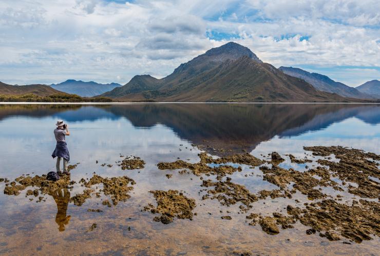 タスマニア州のサウスウェスト国立公園で、美しい景色の写真を撮る男性 © Par Avion/Paul Fleming
