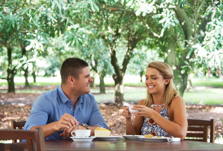 ポート・スティーブンスのメドウィ・マカダミアスでお茶とケーキを楽しむカップル © Destination Port Stephens