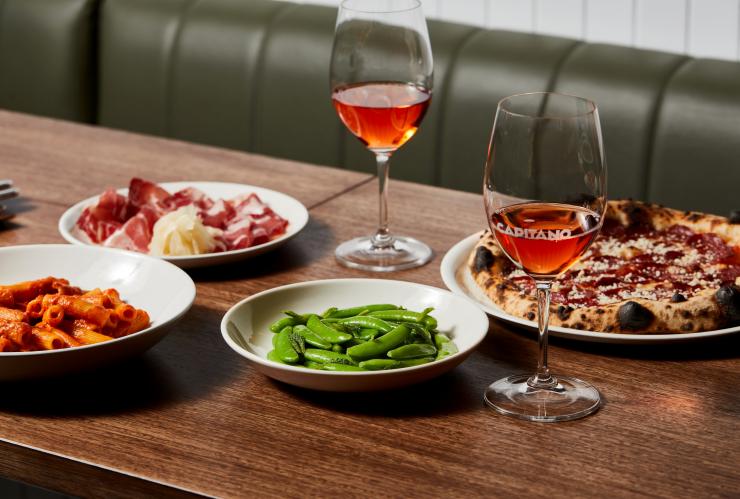 メルボルン、カピターノのテーブルの上に置かれた料理とワイン © Capitano