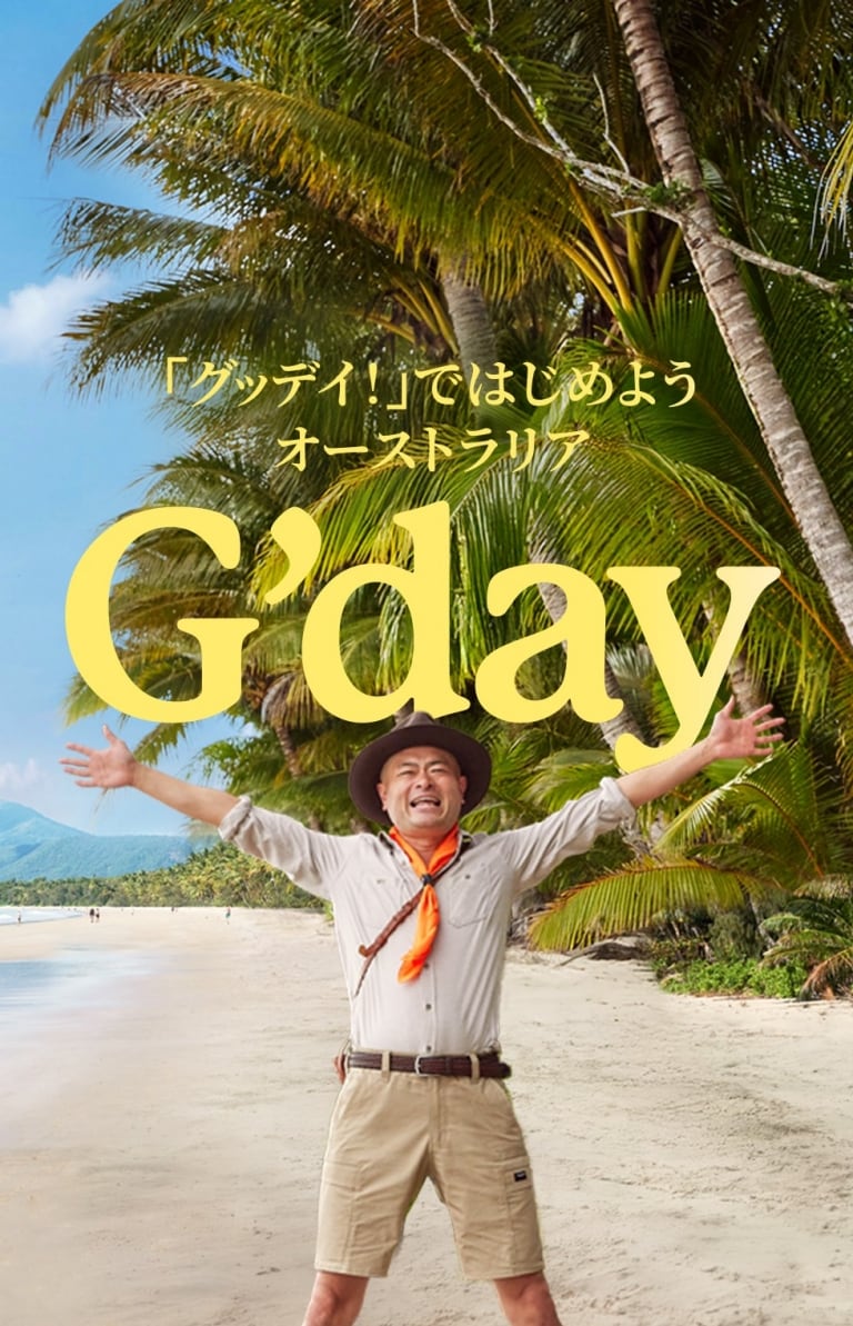 ヤシの木が茂る黄金色のビーチに立っているあばれる君 © Tourism Australia