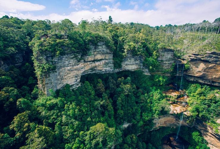 ニュー・サウス・ウェールズ州のブルー・マウンテンズ国立公園の岩の崖と滝の眺め © Tourism Australia