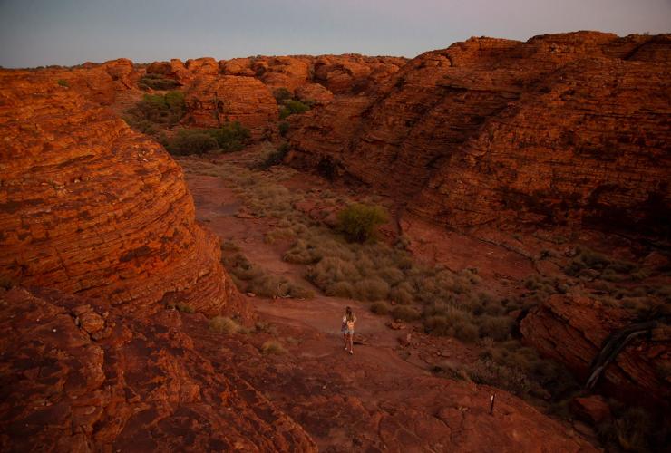 ノーザンテリトリー、キングス・キャニオン、キングス・キャニオン・リム・ウォークの岩の間を歩く女性 © Tourism Australia