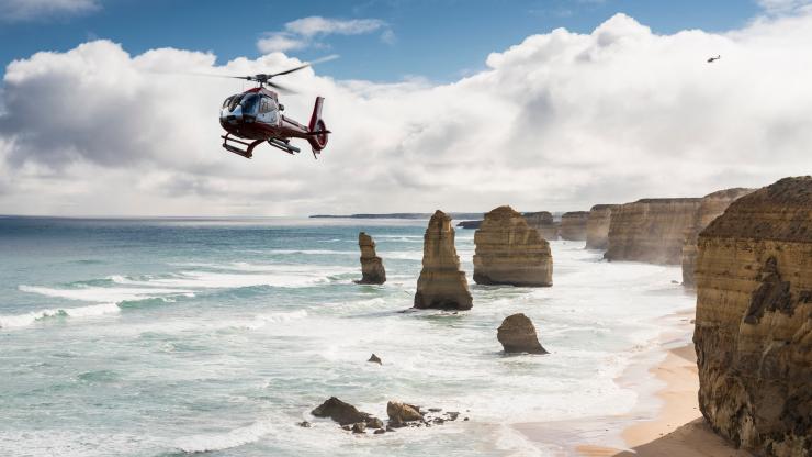 ビクトリア州、グレート・オーシャン・ロード、12使徒の上空を飛ぶヘリコプター © Visit Victoria
