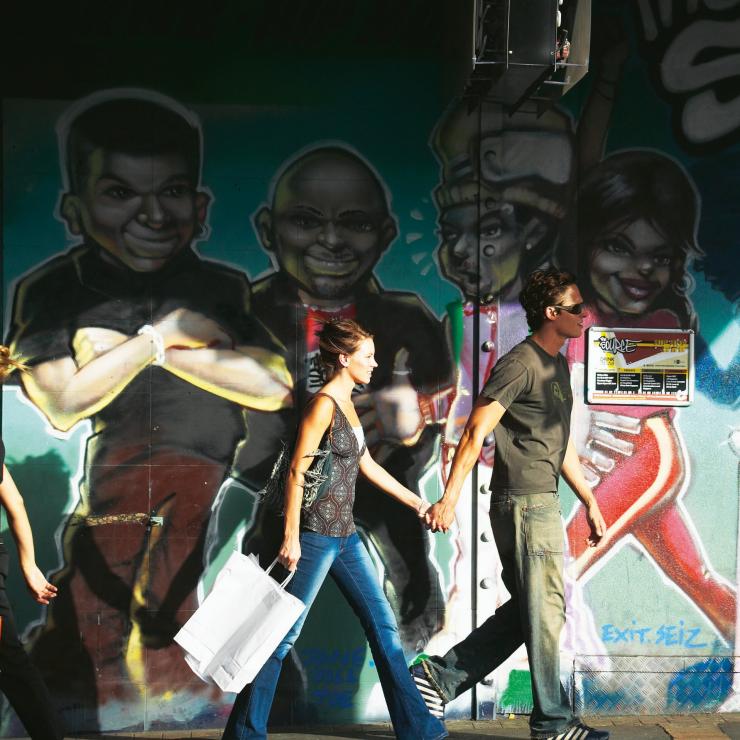앤 스트리트에서 거리 미술로 채워진 벽을 지나가고 있는 행인, 브리즈번, 퀸즈랜드 © 크리스 맥레넌(Chris McLennan)