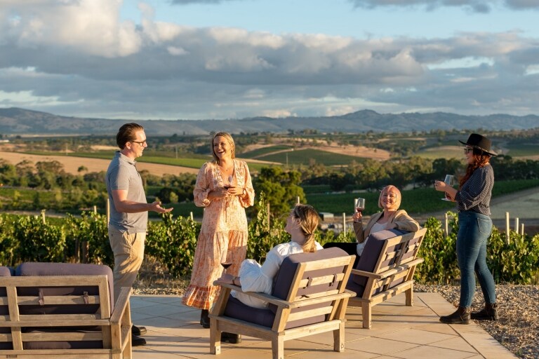 Friends drinking wine overlooking the vineyards at Two Hands Wines, Barossa, South Australia © Tourism Australia