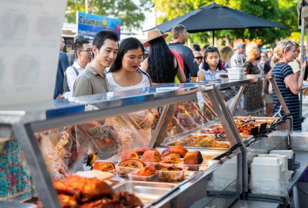 Couple looking at a selection of food at a stall at the Mindil Beach Sunset Markets, Darwin, Northern Territory © Tourism NT/Helen Orr 