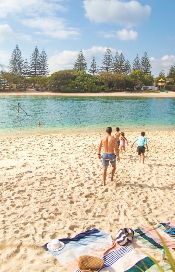 Một gia đình đang chạy trên bãi cát vàng hướng về phía làn nước xanh ngọc, Lạch Tallebudgera, Thành phố Gold Coast, Tiểu bang Queensland © Destination Gold Coast
