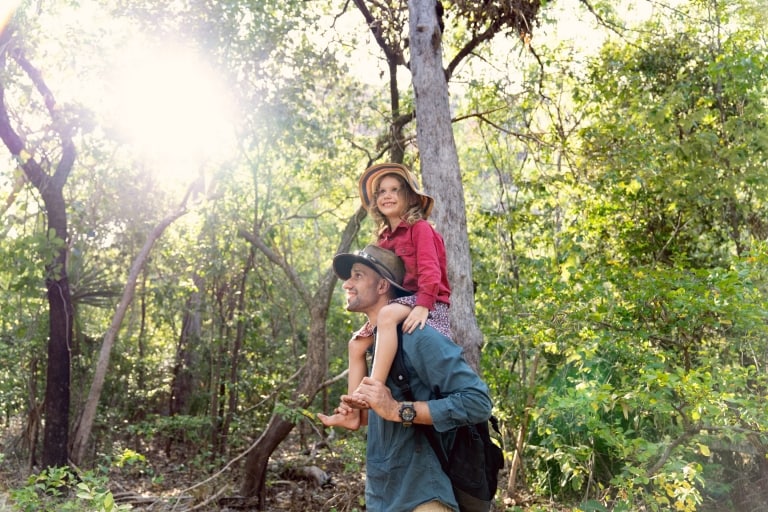 A child sits on her father's shoulders in the forest on a tour with Offroad Dreaming, Kakadu National Park, Northern Territory © Tourism Australia