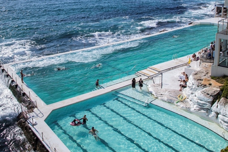 Aerial view over people swimming in the light blue water of Bondi Icebergs at Bondi Beach, Sydney, New South Wales © Destination NSW