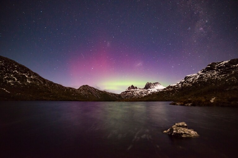 The Aurora Australis (Southern Lights) shining in purple and green hues behind the snow-capped peaks of Cradle Mountain-Lake St Clair National park, Tasmania © Pierre Destribats