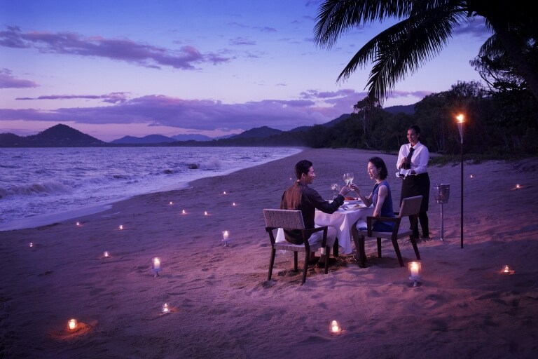 Couple having a candlelit dinner on the beach at Nu Nu Restaurant in Palm Cove © Tourism Australia