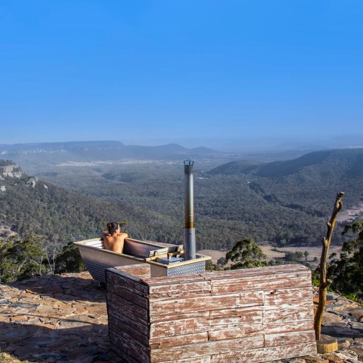 Woman in the bath at Bubbletent Australia looking out over Capertee Valley in the Blue Mountains © Destination NSW