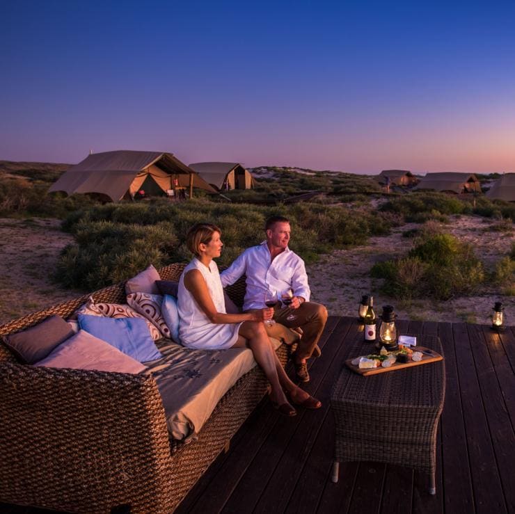 Couple watching sunset at Sal Salis Ningaloo Reef on Australia's Coral Coast © Tourism Western Australia/David Kirkland