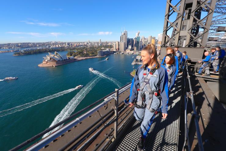 新南威尔士州,万里晴空下,一群游客在悉尼大桥攀登公司的安排下,在悉尼海港大桥上俯瞰海港 © David Gray 版权所有 新南威尔士州,万里晴空下,一群游客在悉尼大桥攀登公司的安排下,在悉尼海港大桥上俯瞰海港 © David Gray 版权所有