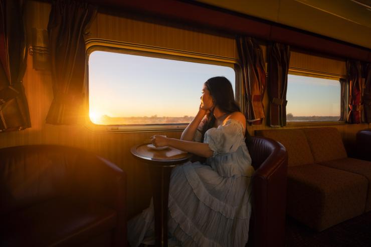 一個女人在甘號列車上享用熱飲©北領地旅遊局/Daniel Tran