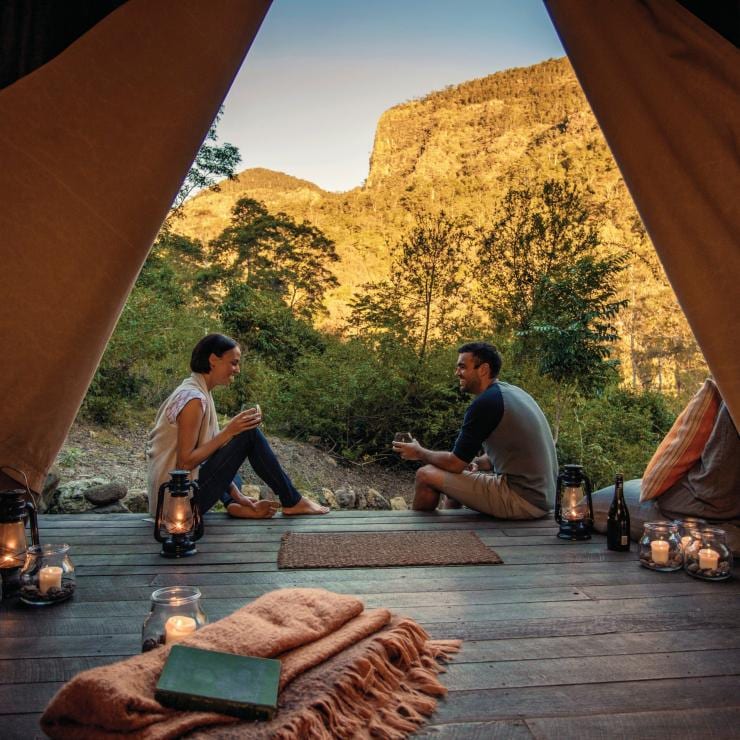 情侶坐在昆士蘭州夜幕荒野露營地的豪華野營帳篷內©夜幕荒野露營地