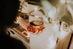 Main tenant une tasse de café © Cassiopeia Specialty Coffee