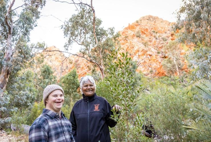 Ein Mann mit Neurodivergenz erkundet Standley Chasm zusammen mit einem Guide, West MacDonnell Ranges, Northern Territory © Tourism NT/Helen Orr