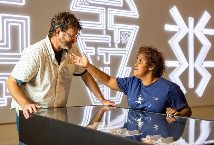 Eine Frau mit Neurodivergenz steht neben einem Mann, und die beiden genießen das Araluen Arts Centre, Alice Springs, Northern Territory © Tourism NT/Helen Orr